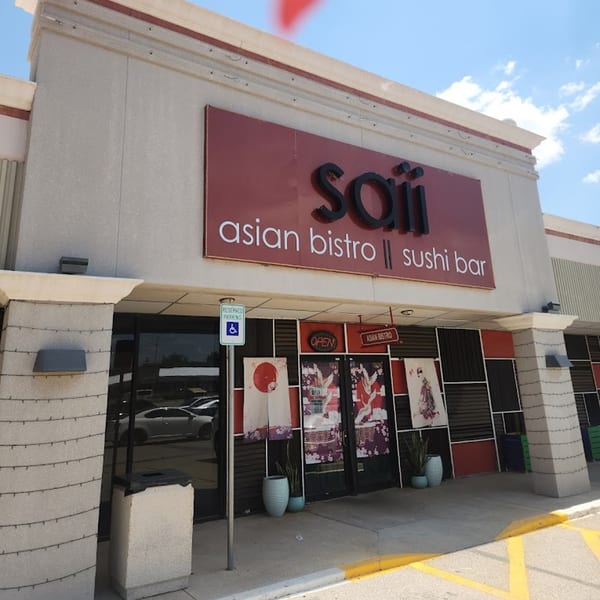 Exterior of Saii Asian Bistro and Sushi Bar, with a red sign and Japanese-themed window decorations.